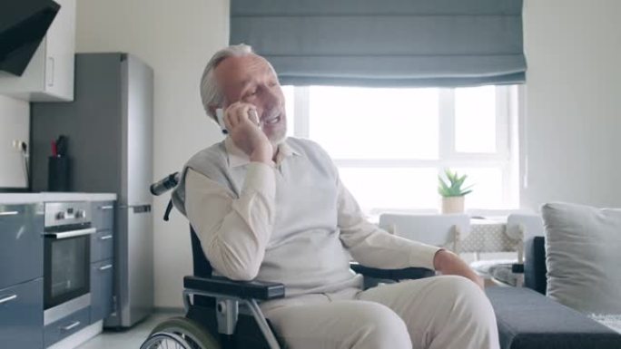 满意的老人坐在轮椅上讲电话，养老院服务