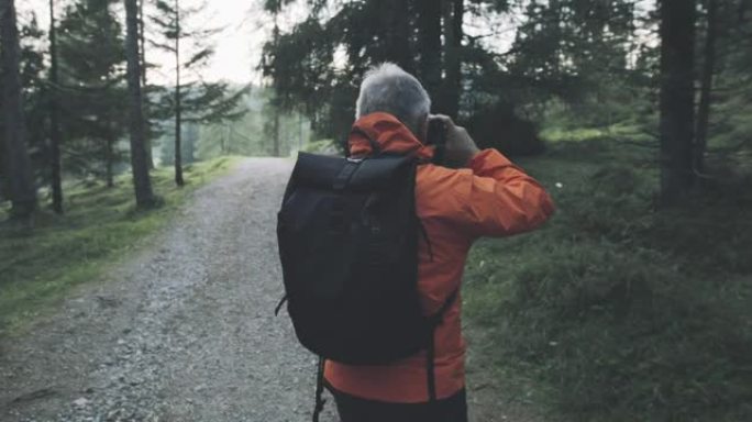 资深摄影师在意大利多洛米蒂森林徒步旅行，拍照