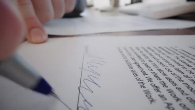 特写移动微距镜头: 男性手中的笔在合同上签名。在室内办公室工作时签署交易文件。编写商业协议或协议的签