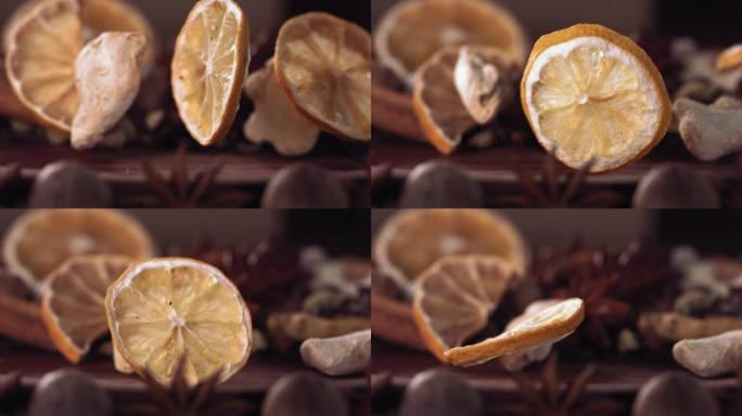 柠檬片和生姜落在木头上的香料中。慢动作