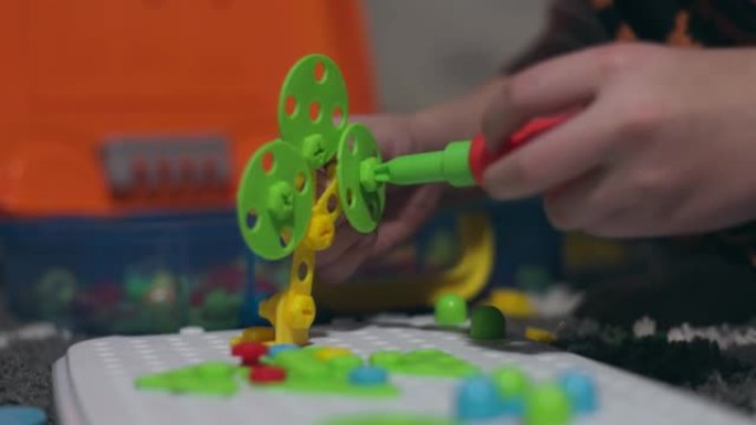 儿童玩儿童教育建设者拼图与螺丝刀，螺栓和螺丝与多色几何图形