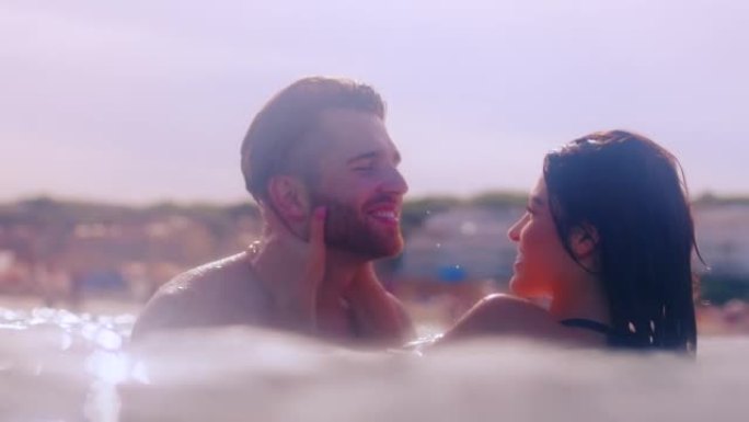 浪漫的异性恋夫妇一起在海里游泳。拥抱和亲吻