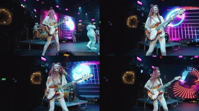 时尚女吉他手留辫子在舞台上嬉戏跳舞，摇滚音乐音乐会