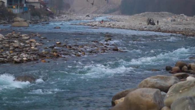 印度喜马al尔邦Manali的Beas河在岩石之间流动的特写镜头。流经喜马拉雅山脉的河流。自然河背景