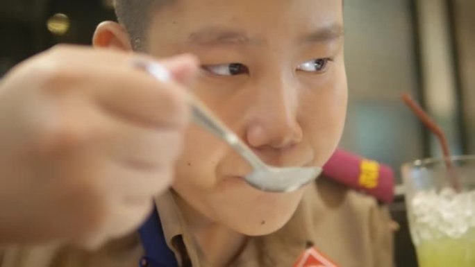 亚洲童子军与家人一起在自助餐厅吃蘑菇汤。