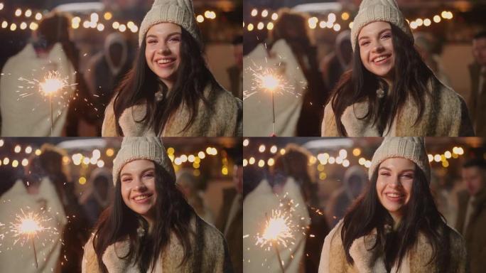 午夜在城市广场的圣诞快乐派对上，带着火花的漂亮女人的肖像，微笑着
