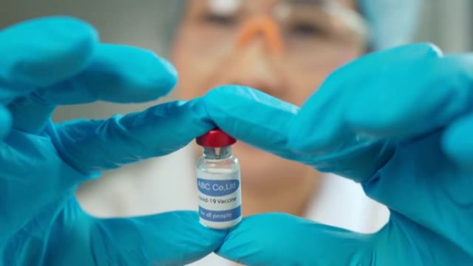 女科学家手持安瓿，新药开发，疫苗接种，新型冠状病毒肺炎冠状病毒疫苗小瓶。