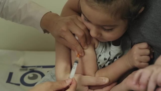 女医生在实验室给微笑的女孩接种新型冠状病毒肺炎疫苗
