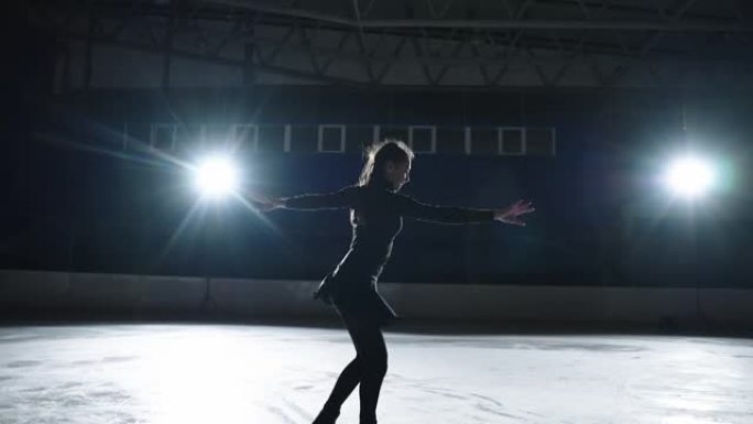 慢动作: 年轻的女性艺术花样滑冰运动员的电影镜头在比赛开始前在溜冰场上表演女子的单人滑舞蹈。自由概念