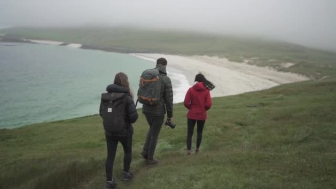 朋友在沿海探险中徒步穿越海边草丛