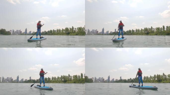 站立桨板 (SUP) 的第一人称视角，漂浮在城市河上