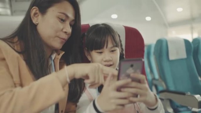 母亲和女儿在飞行中使用智能手机