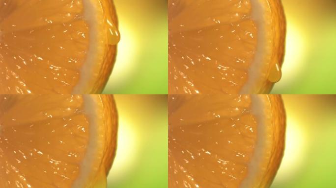 一滴水从成熟多汁的橙色切片的表面流下。慢动作4K