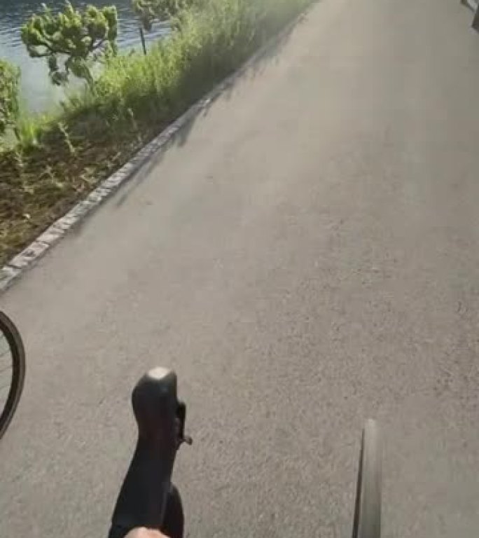 在湖泊附近的道路上，公路自行车手的垂直镜头