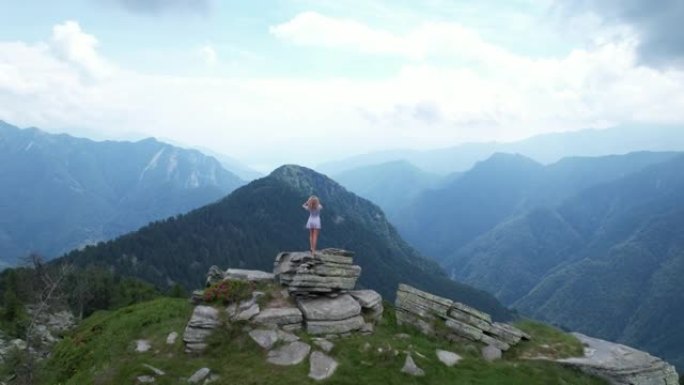 女人站在岩石山脊上，远处的山脉