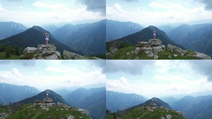 女人站在岩石山脊上，远处的山脉