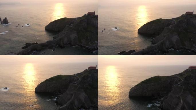 日落时的Gaztelugatxe岛。曝光不足的视频和阳光反射在比斯开高尔夫水上。