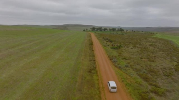 在乡村土路上独自行驶的小型货车的前瞻性跟踪。风景中汽车的鸟瞰图。南非