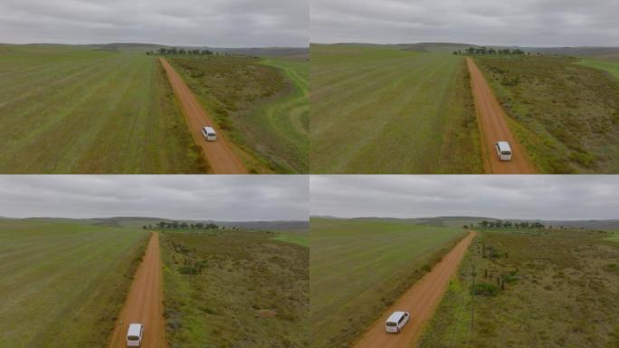 在乡村土路上独自行驶的小型货车的前瞻性跟踪。风景中汽车的鸟瞰图。南非