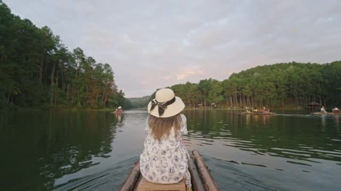 坐在竹船上的女人欣赏自然。森林和湖景