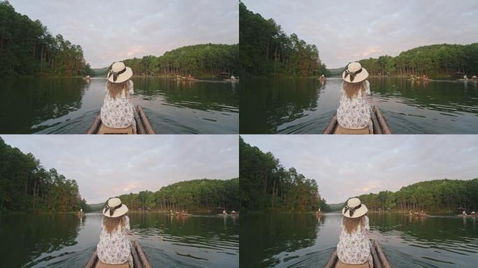 坐在竹船上的女人欣赏自然。森林和湖景