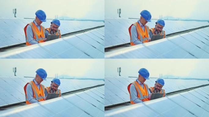 两名男性工程师在屋顶太阳能发电厂工作，并用数字平板电脑检查光伏电池板的操作