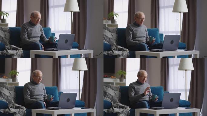 男性退休人员正在使用笔记本电脑通过与朋友或家人的视频聊天，看着网络摄像头和喝茶进行交流