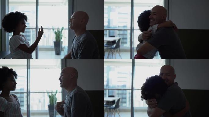 女儿与聋哑的父亲交谈并在家里拥抱他
