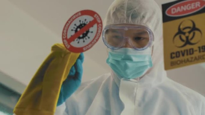 新型冠状病毒肺炎: 亚洲男子穿着防护服，手套和消毒湿巾