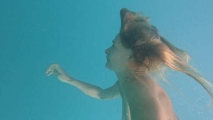 年轻女子在清澈的海水中游泳的第一人称视角