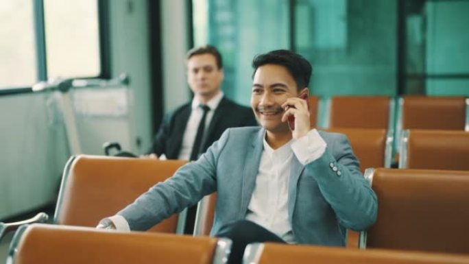 亚洲商人在机场使用智能手机