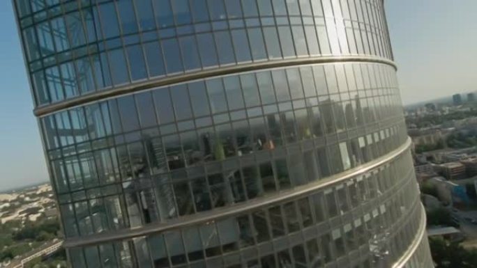 映照蓝天的玻璃摩天大楼。FPV无人机在建筑物上移动