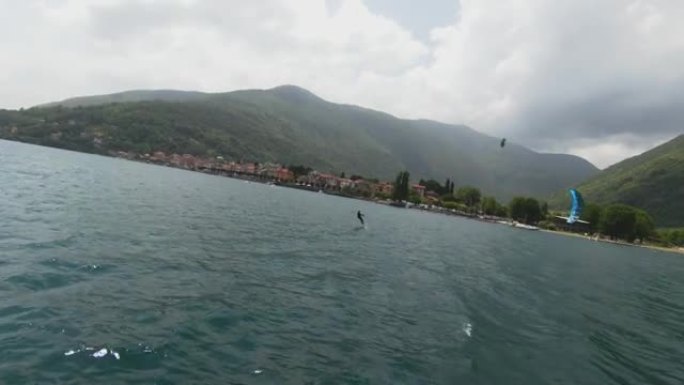 空中无人机拍摄了一名男子在山上的湖上冲浪的风