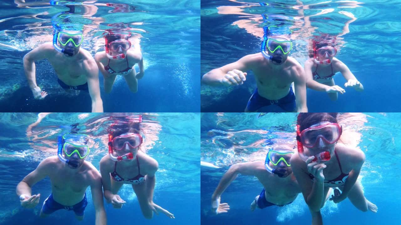 夏天在海里浮潜。夫妇在可穿戴相机前玩得开心。水下射击