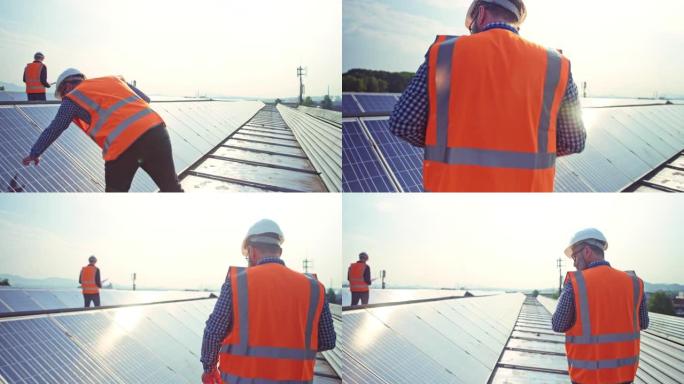 TS男工程师检查太阳能电池板在屋顶发电厂上穿过一排