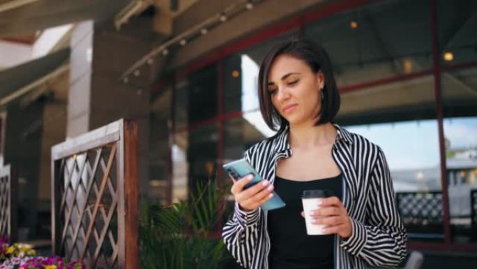 城市咖啡馆女性社交媒体用户的肖像，女士拿着咖啡杯在智能手机屏幕上滑动
