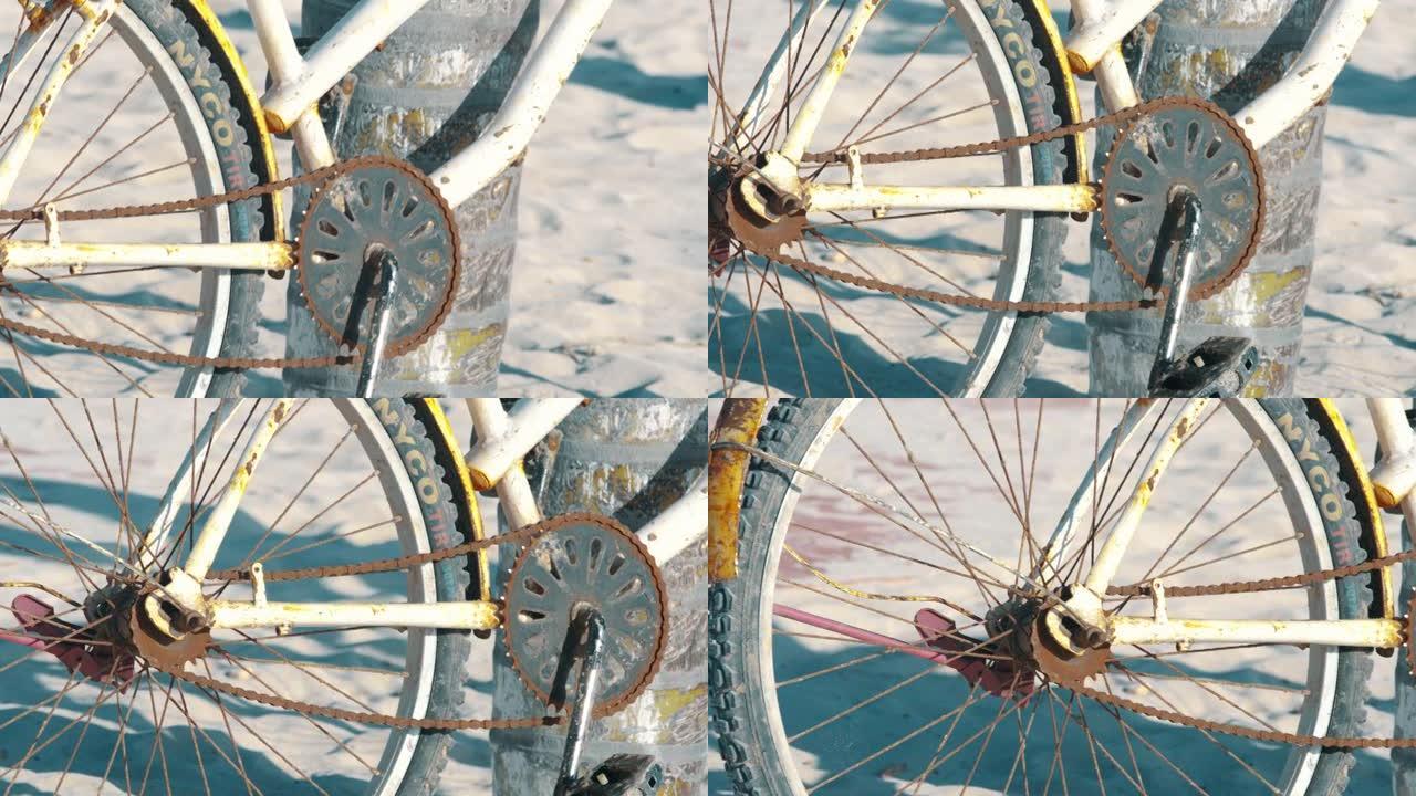 在海滩上关闭一辆生锈的旧自行车的细节照片