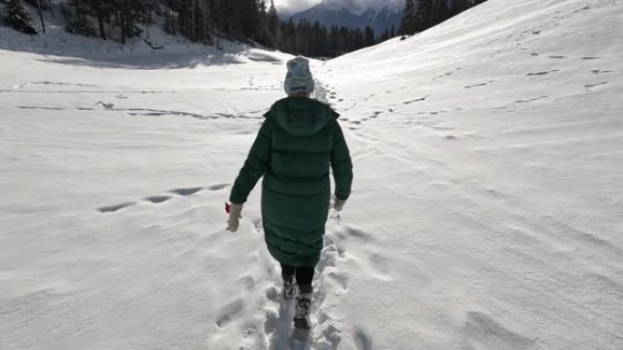 女人在冬季风景中穿越雪中时的第一视角