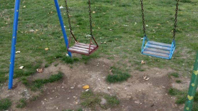 两个空链摆动留给自己摆动。公园里没有孩子。高角度视图