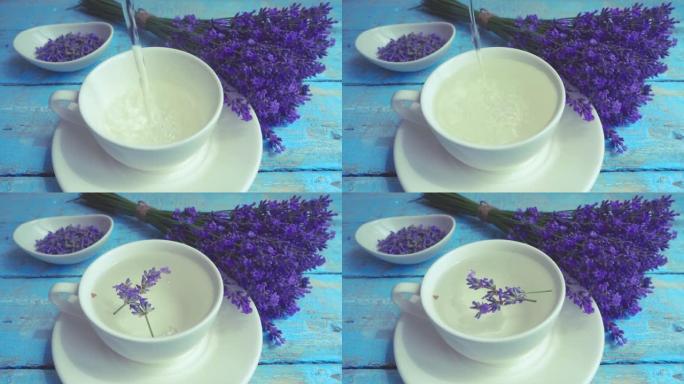 复古木制背景上的淡紫色鲜花茶。一股沸水倒入杯子。带有薰衣草花瓣的下降树枝。慢动作。