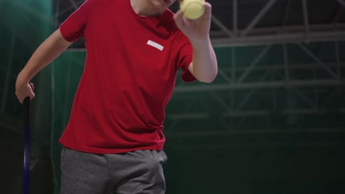 年轻的运动员正在网球场上训练，将球扔在地板上并接球，锻炼男网球运动员