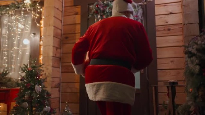 圣诞老人手里拿着礼物，进入儿童之家，在圣诞树下留下礼物。装饰圣诞屋