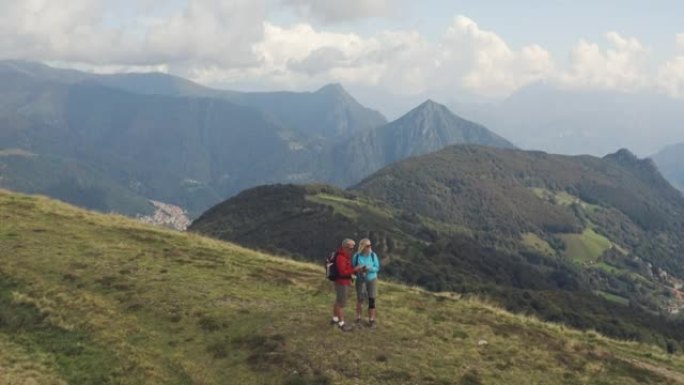 夫妇在山上徒步旅行时停下来欣赏风景