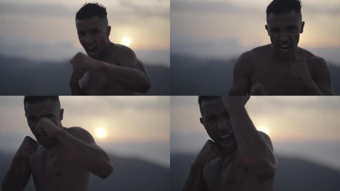 男运动员在悬崖上训练。在镜头前练习拳击动作和拳打