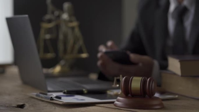 检察官办公室，在在线咨询概念台的律师和合法虎皮旁边的秤雕像前的笔记本电脑锤子。4k视频。