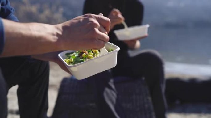 两个朋友用可堆肥的碗和叉子吃健康餐