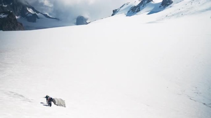 陡峭的山坡。雄伟的勃朗峰和遥远的登山者剪影