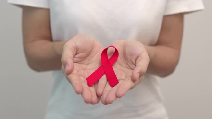 手捧红丝带，12月世界艾滋病日、获得性免疫缺陷综合症、多发性骨髓瘤癌症宣传月和全国红丝带周。医疗保健