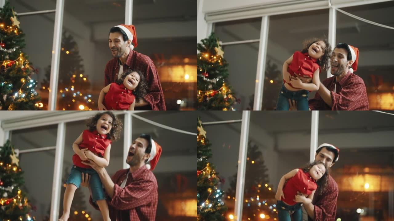快乐的父亲抱着女儿在圣诞节之夜飞翔。