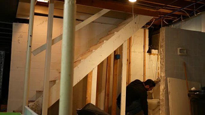 承包商或水管工在房屋改建过程中看着漏水的厕所